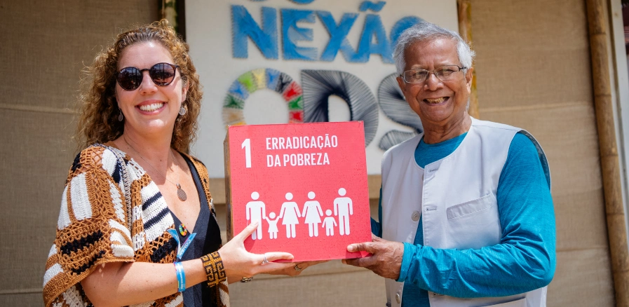 Homem e mulher segurando prêmio de ODS